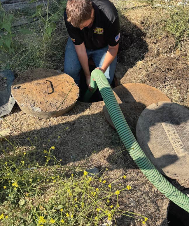 Technicians from Rescue Hero Plumbing perform sewer line cleaning to prevent backups in a home.