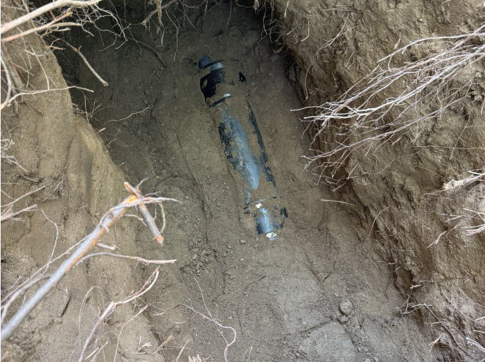 Excavated sewer line revealing a broken connection point that requires repair to prevent septic system failure.