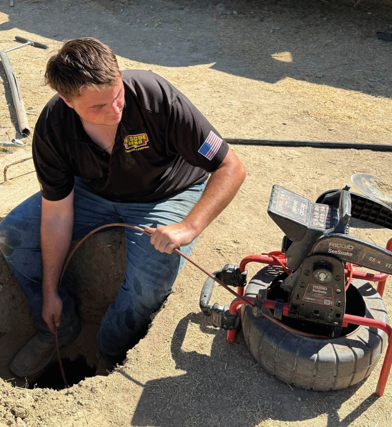 Professional plumber in Wofford Heights using a RIDGID SeeSnake video camera for a precise sewer line inspection to identify blockages or pipe damage.