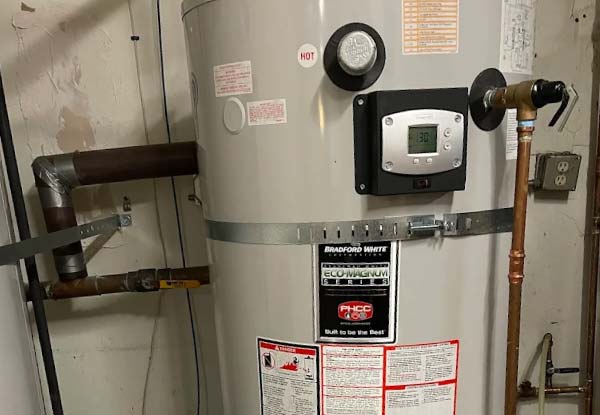 plumbing technician performing diagnostic electrical testing on a residential water heater thermostat control.