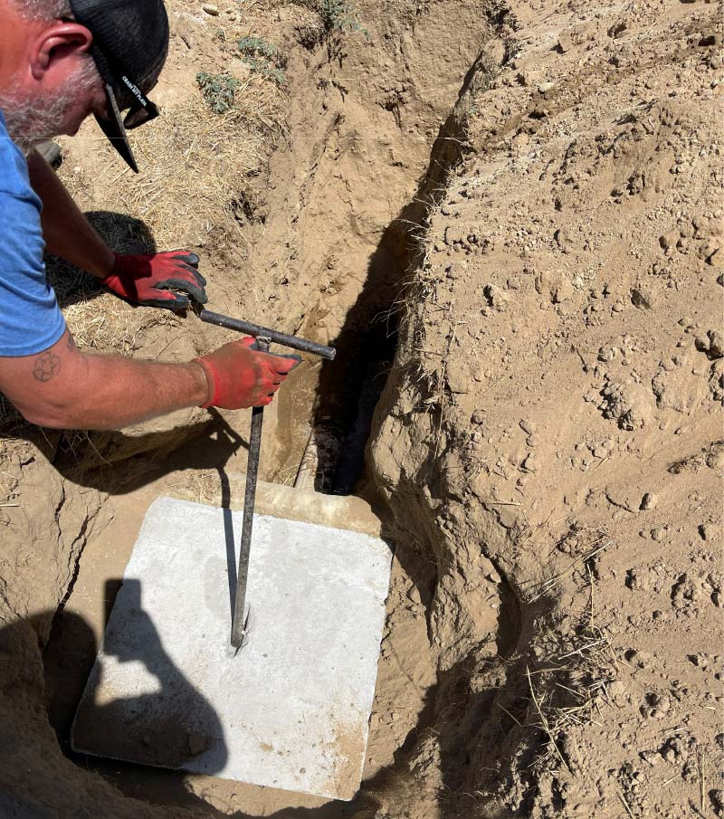 Professional plumber in a blue uniform repairing water lines
