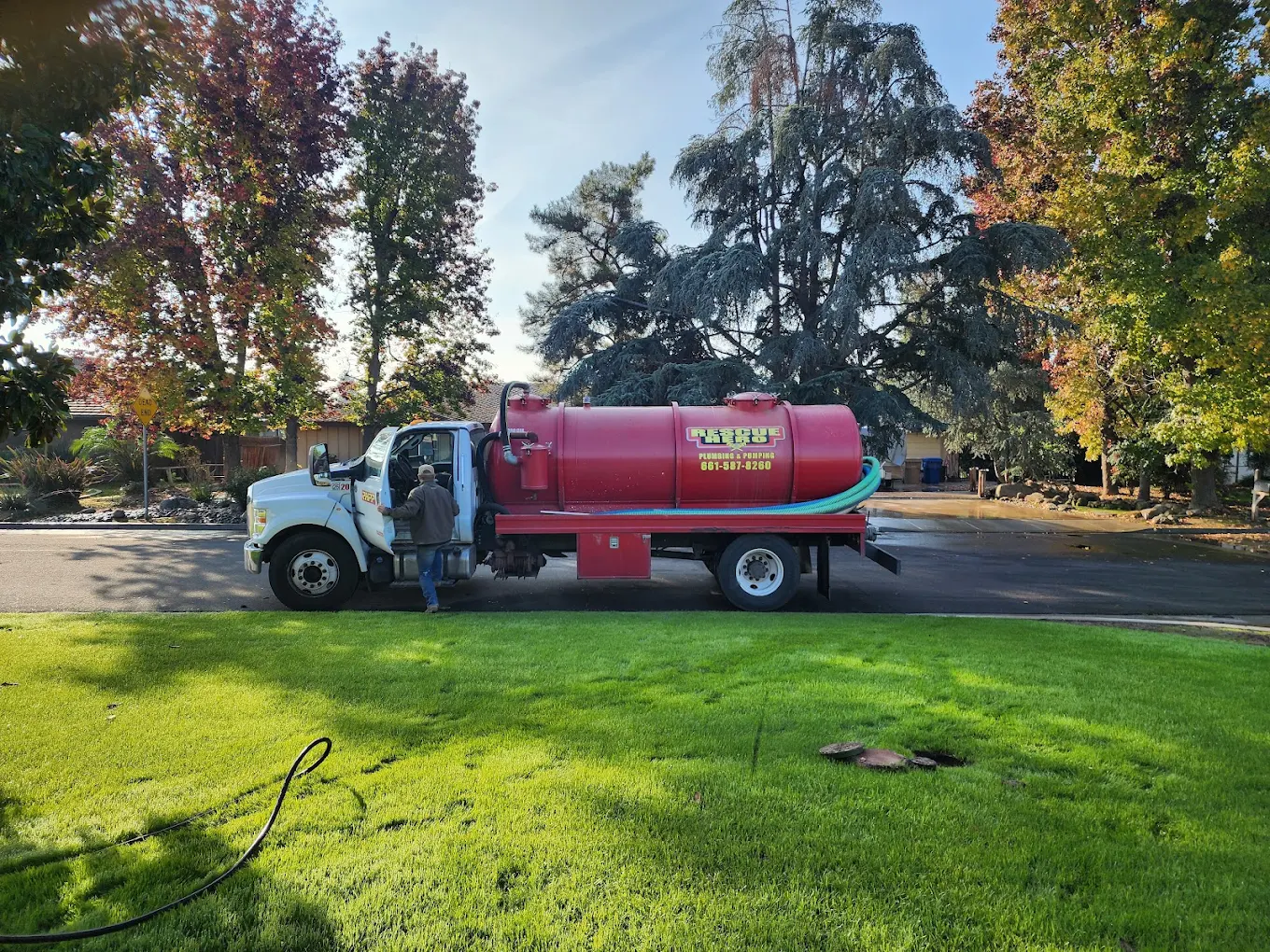 Large capacity industrial vacuum pumping truck parked on-site for septic system main line clearing.