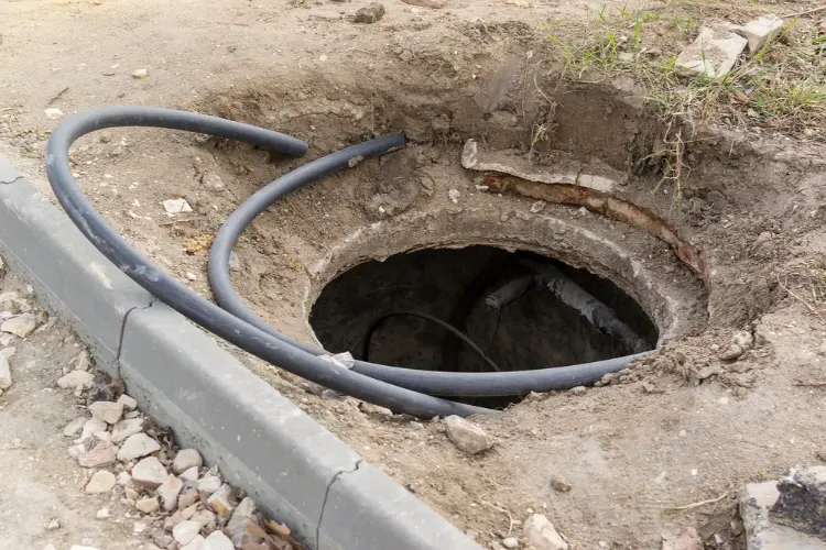Small access pit with pipe conduit exposed, used for trenchless sewer line repair in Bakersfield, CA